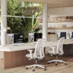 Caesarstone ICON 4001 Fresh Concrete in Modern office with ergonomic chairs, multiple computers, wooden flooring, and green plants.