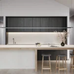 Caesarstone Quartz 4011 Cloudburst Concrete surface in Modern kitchen with minimalist design, black cabinetry, wooden island, stools, and large window.