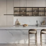 Caesarstone Quartz 5031 Statuario Maximus surface in Modern kitchen with marble island, two bar stools, upper glass cabinets, and minimalist decor.