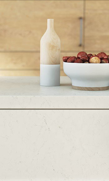 Caesarstone ICON 5141 Frosty Carrina in Minimalist bathroom sink with brass faucet, pendant light, toiletries on wooden tray, and wicker basket.