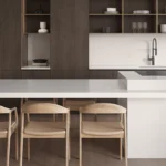 Caesarstone Quartz 6141 Ocean Foam surface in Modern kitchen with white island, wooden chairs, open shelves, minimalist decor, and built-in sink.
