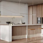 Caesarstone Porcelain 412 Beige Cement in Modern kitchen with wooden cabinets, white island, pendant light, two stools, and built-in appliances.